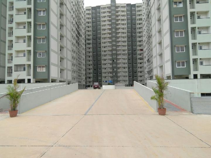 Modern apartment building exterior with balconies and windows, surrounded by trees_brandestate.in